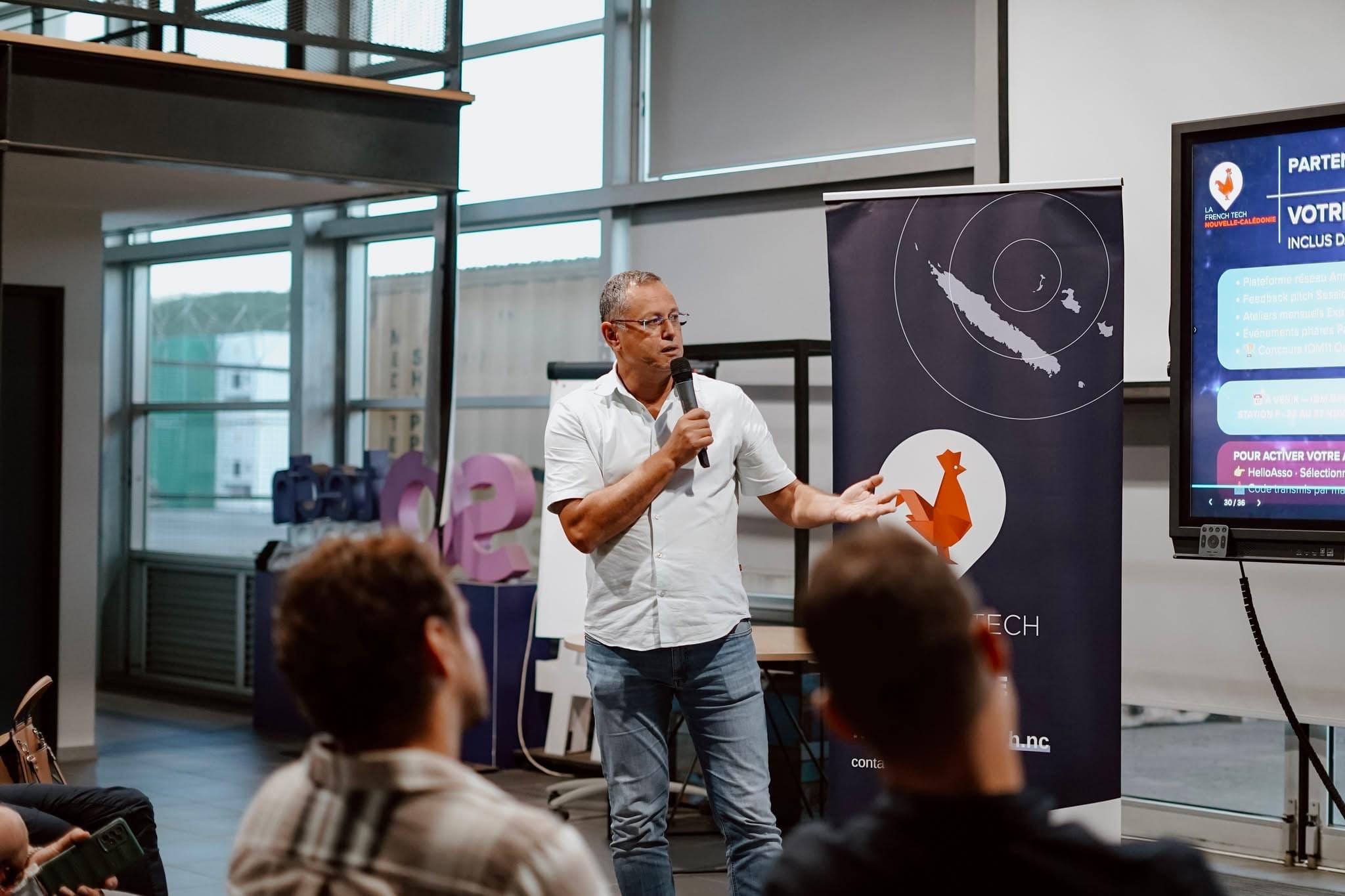 Un intervenant au micro devant le kakémono de La French Tech Nouvelle-Calédonie