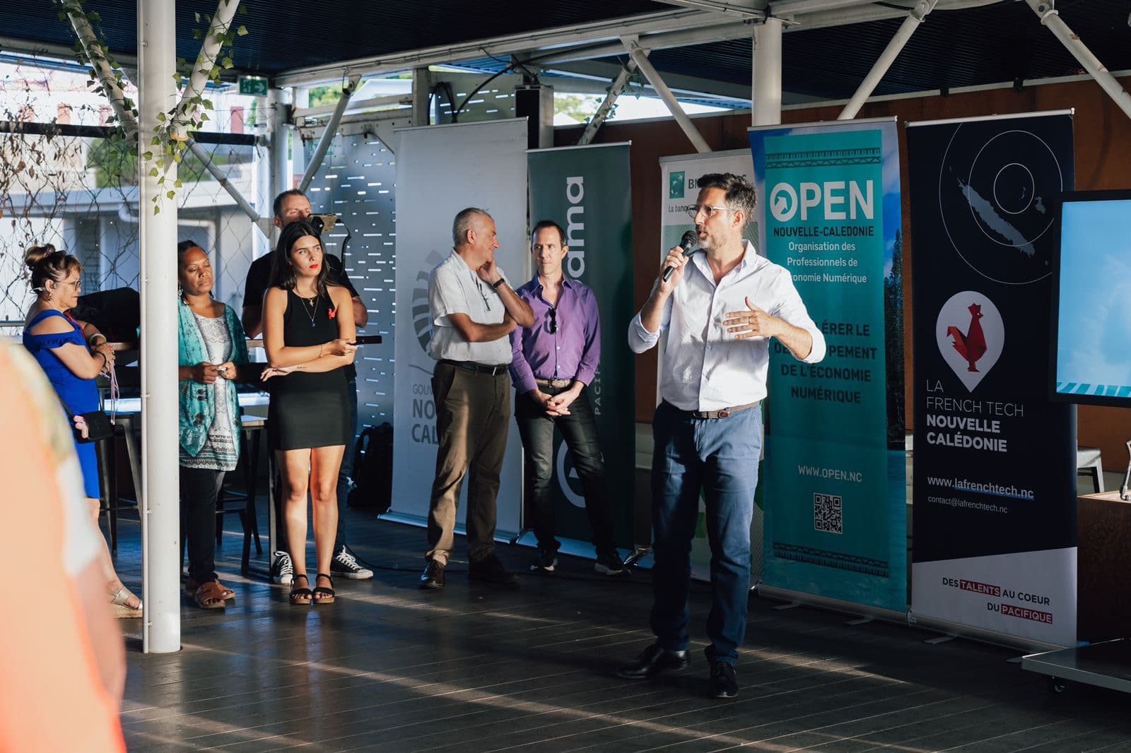 Un intervenant prend la parole devant les kakémonos d’OPEN NC et de La French Tech Nouvelle-Calédonie